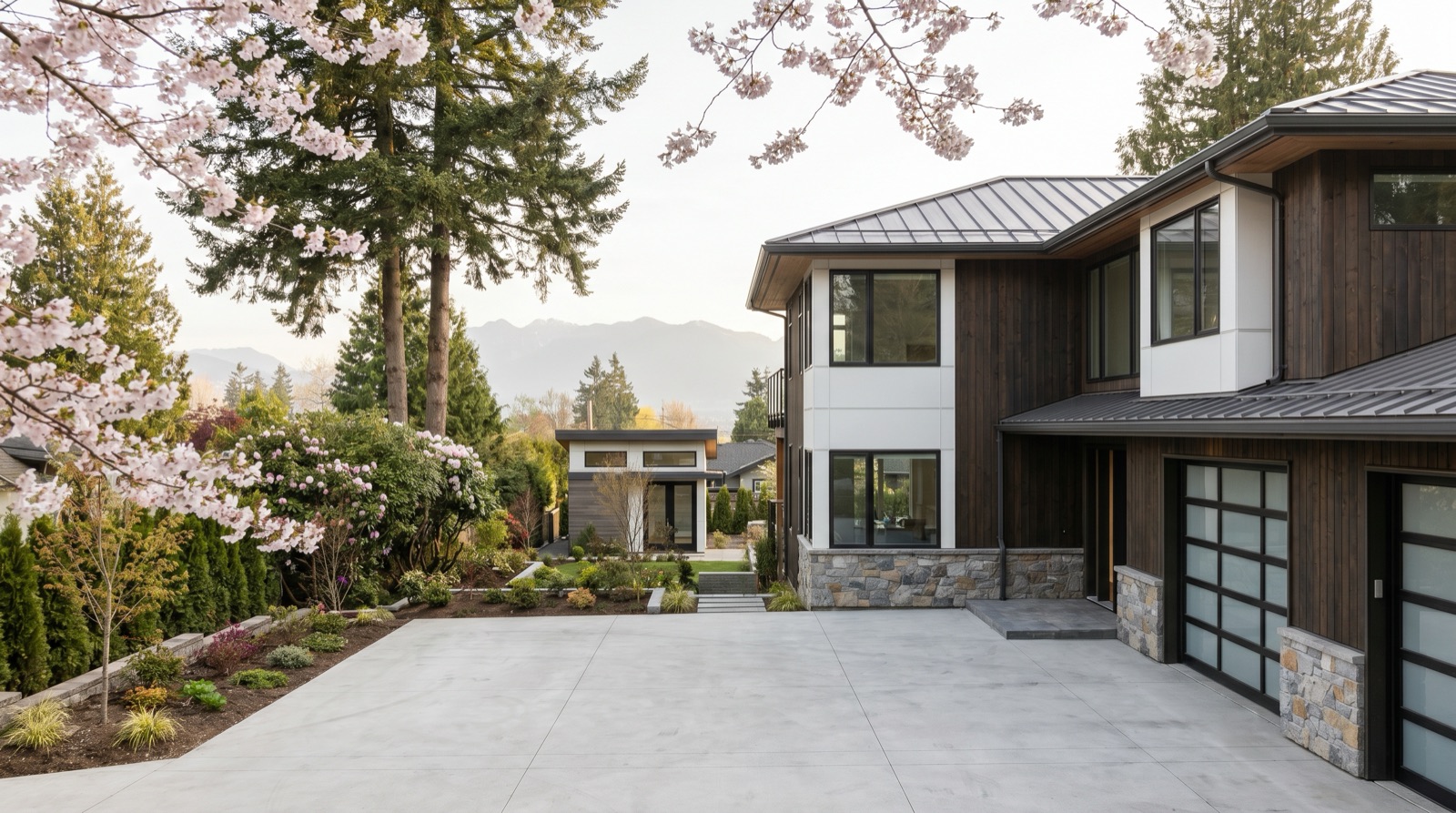 Burnaby BC residential street in Buckingham Heights neighbourhood with a newly built modern custom single family home on a large lot with mature trees and mountain views in the background representing why SFH construction still pencils on premium Burnaby lots in 2026
