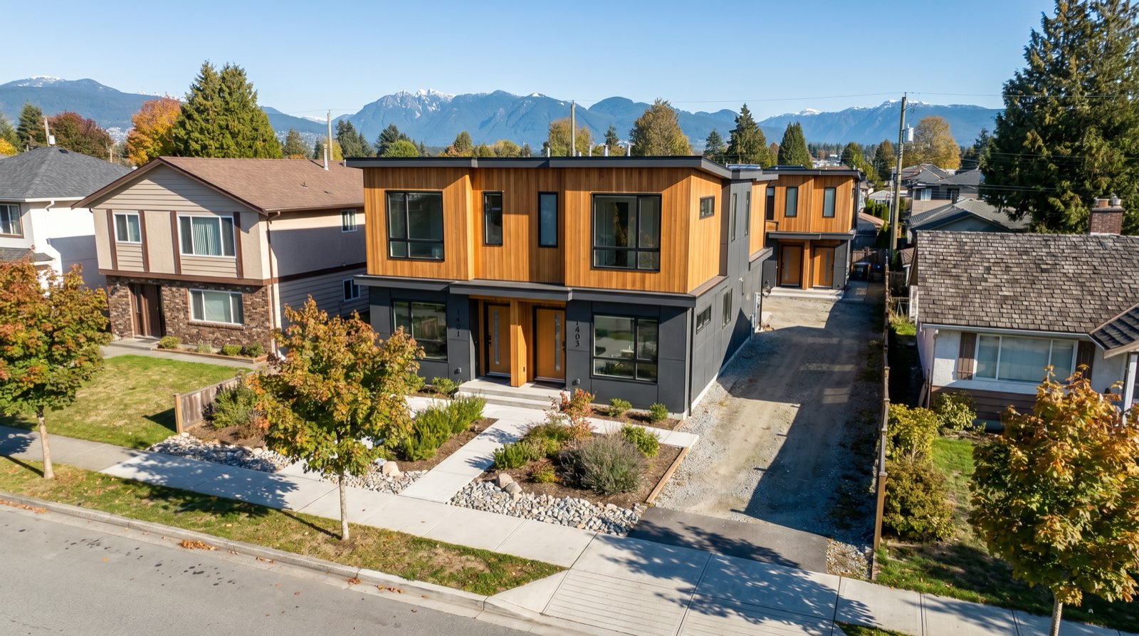 Aerial view of a Coquitlam residential neighbourhood with ground-oriented multiplex buildings and a schematic overlay of water and sewer service lines representing the SSMUH available fire flow servicing capacity map