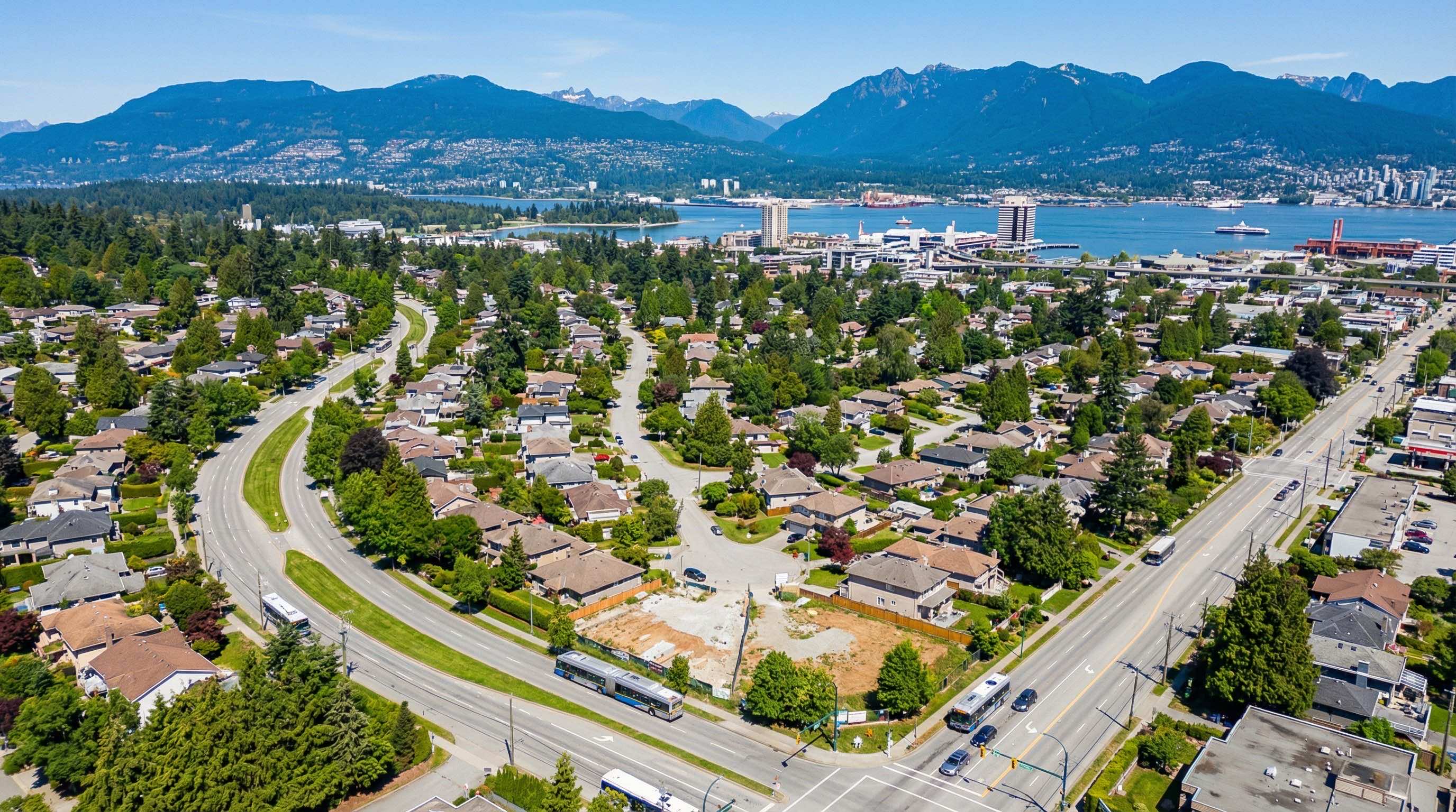 Aerial view of North Vancouver neighborhoods with transit corridors and mountain backdrop