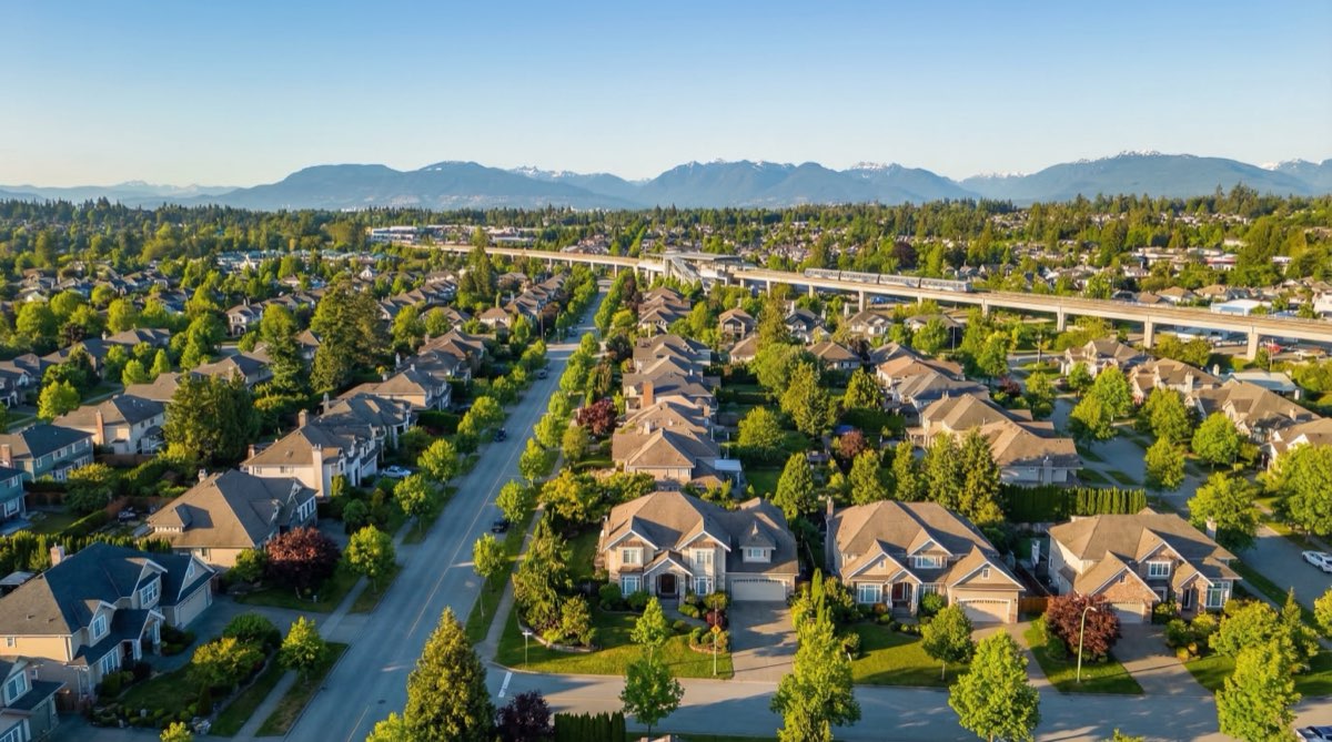 Aerial view of Surrey residential neighbourhood showing large lots in Newton with multigenerational housing potential and SkyTrain corridor in the distance